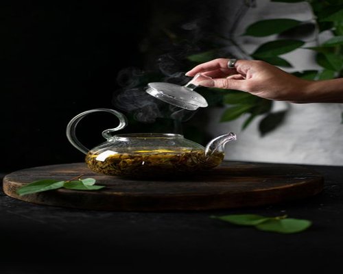 A glass teapot brewing fresh lemongrass