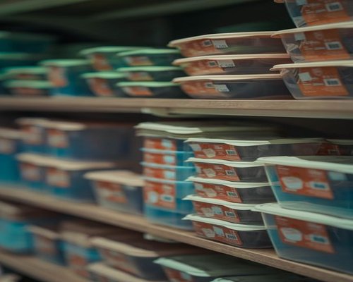 Neatly arranged and covered food storage containers in a pantry